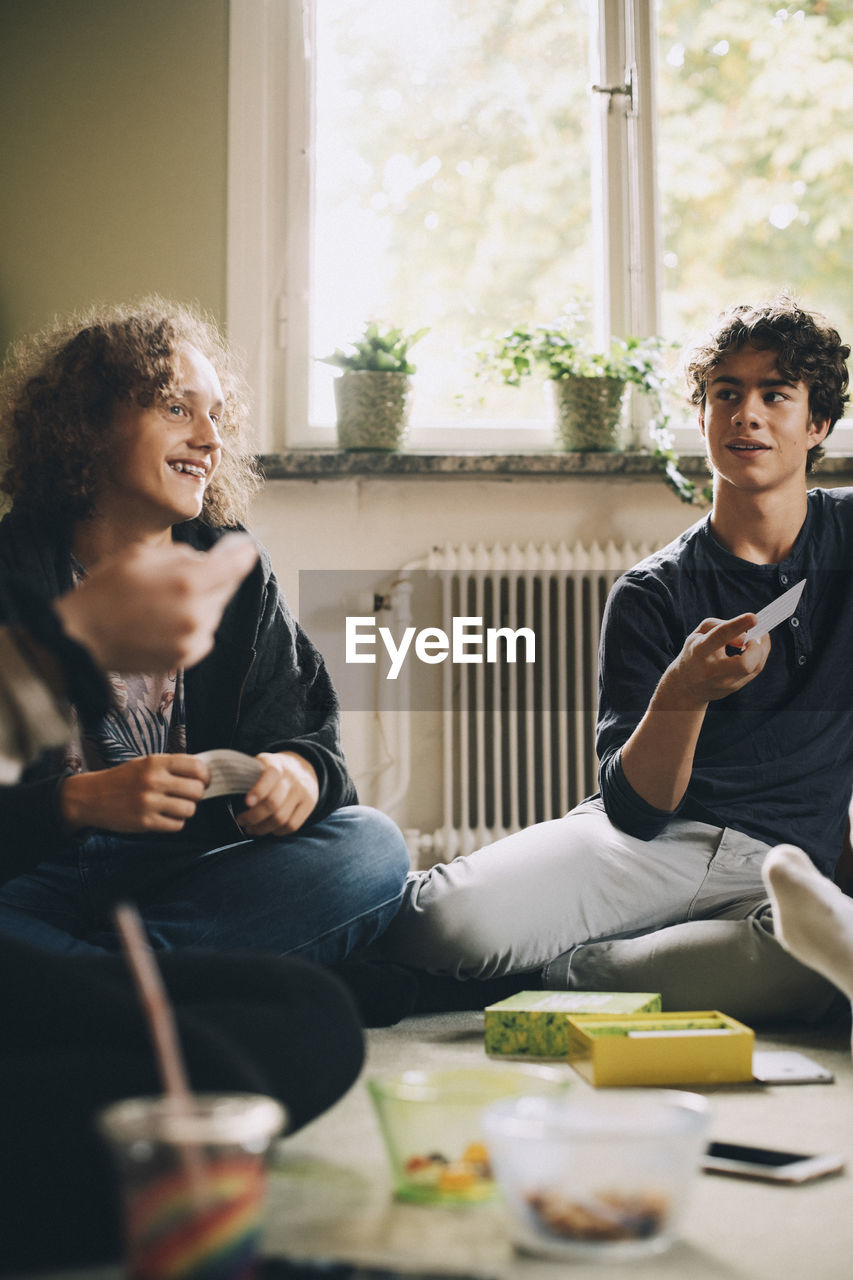 Male friends talking while playing board games at bedroom