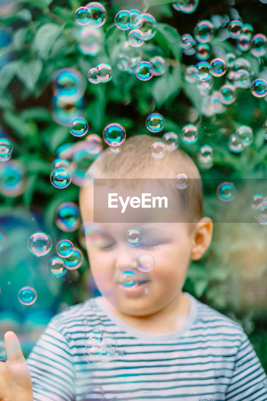 Portrait of cute boy blowing bubbles