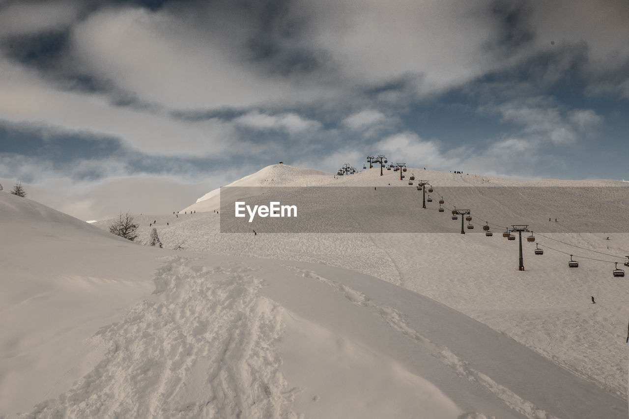 Scenic view of snowcapped mountains against cloudy sky