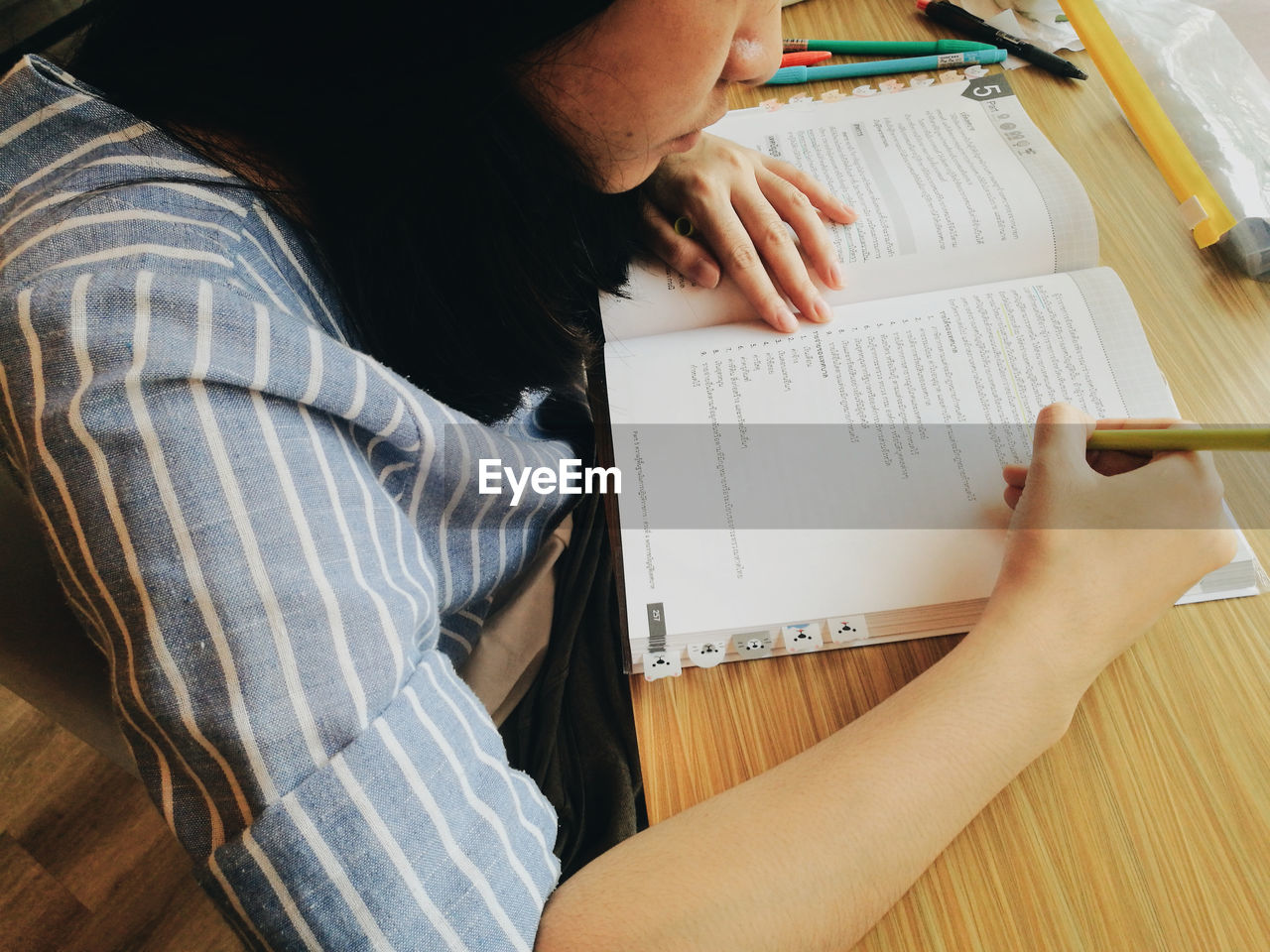 Midsection of young woman studying on table  