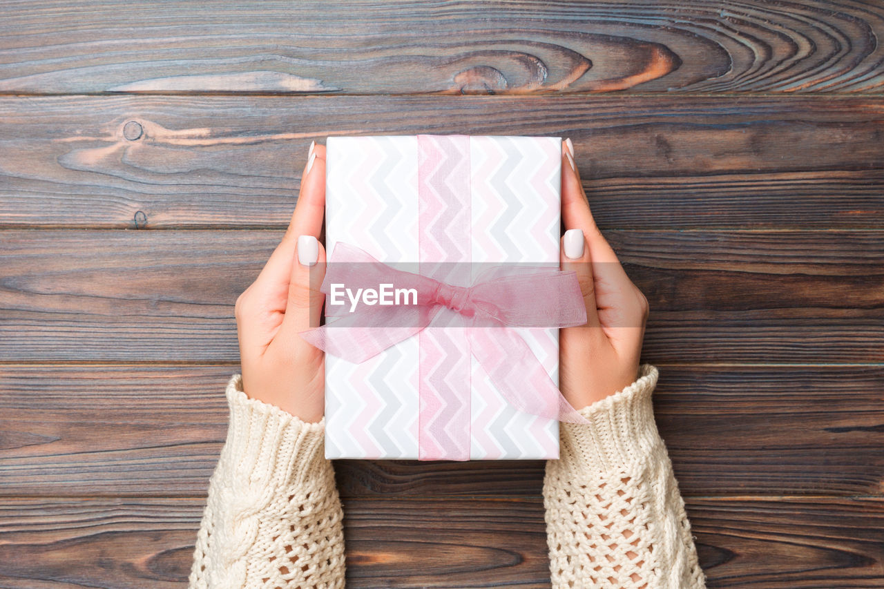 Cropped hands of woman holding gift