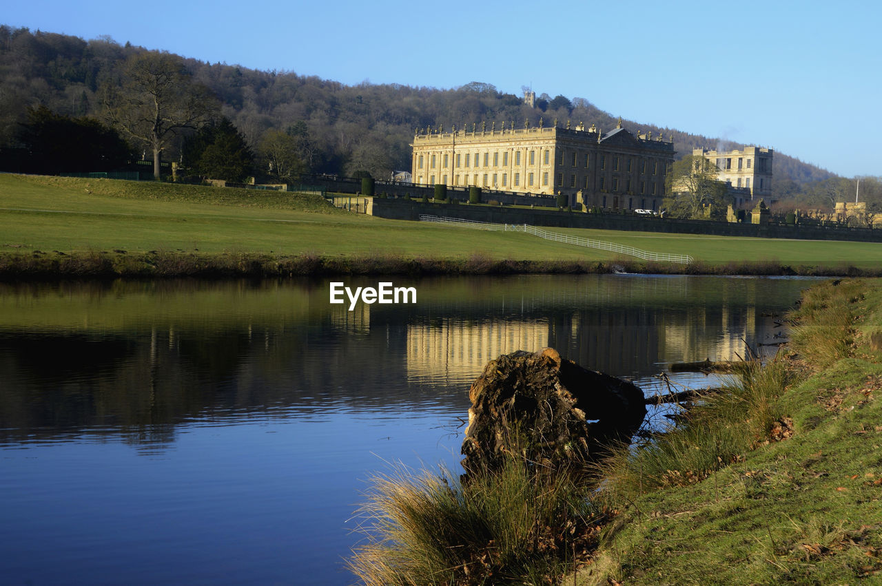 LAKE BY BUILT STRUCTURE AGAINST SKY