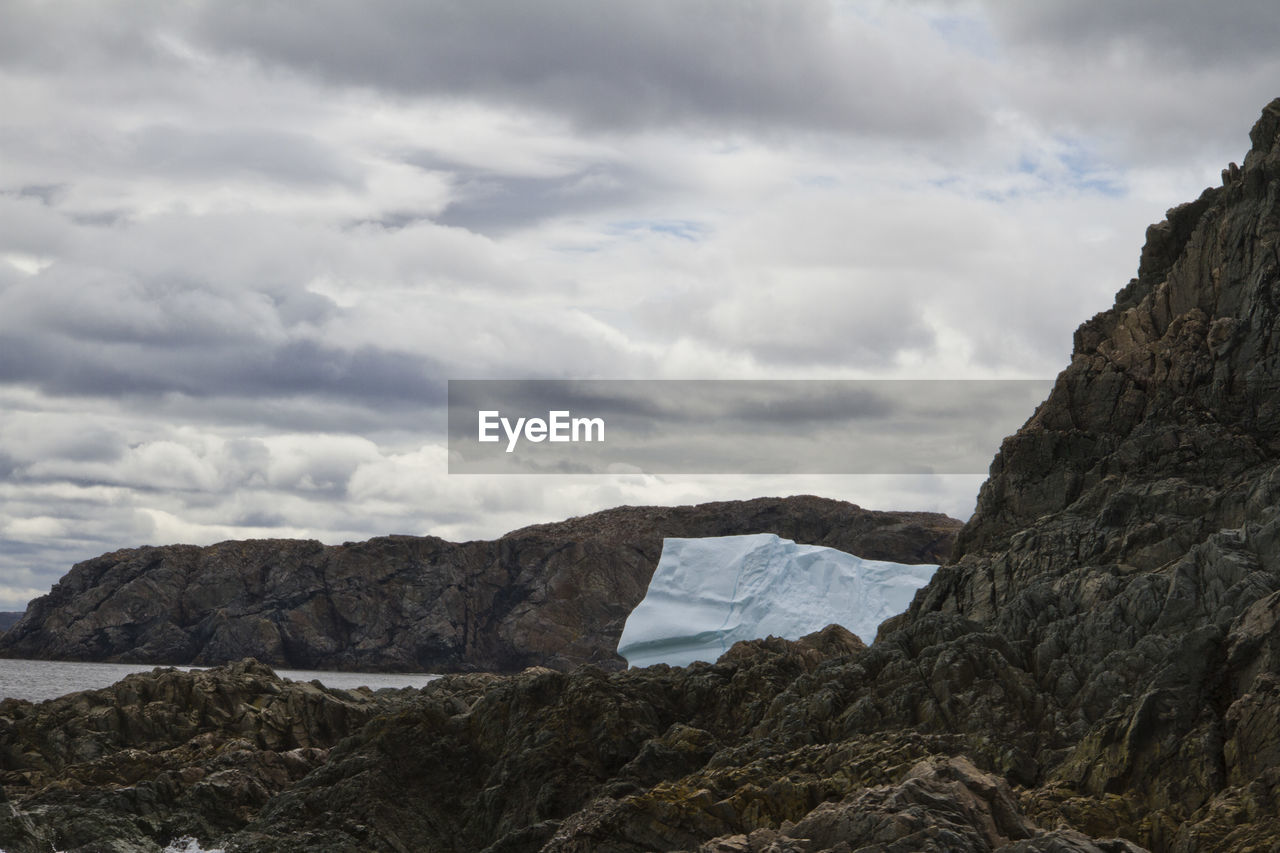 Scenic view of mountains against cloudy sky