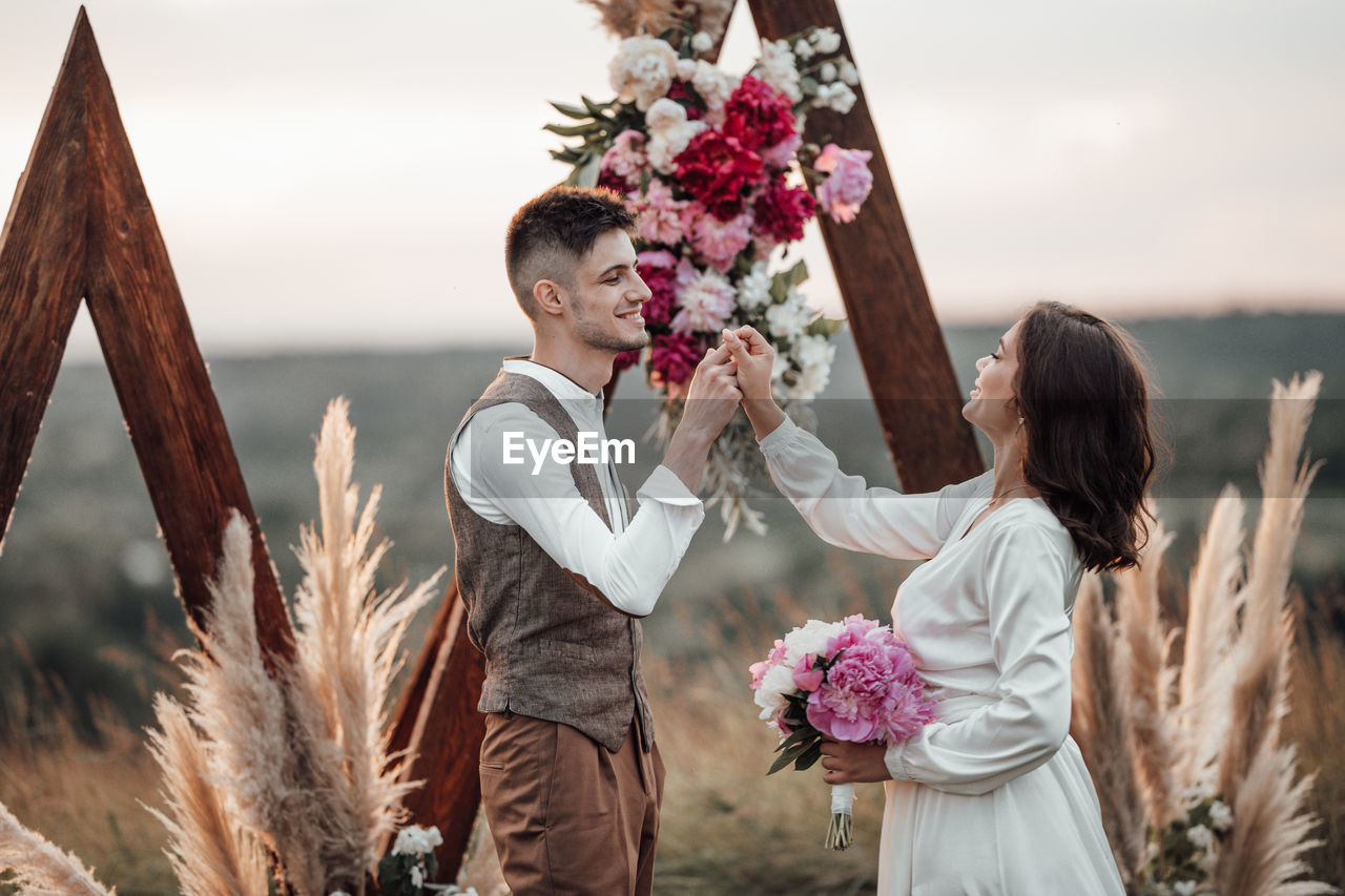 Young couple holding flower bouquet