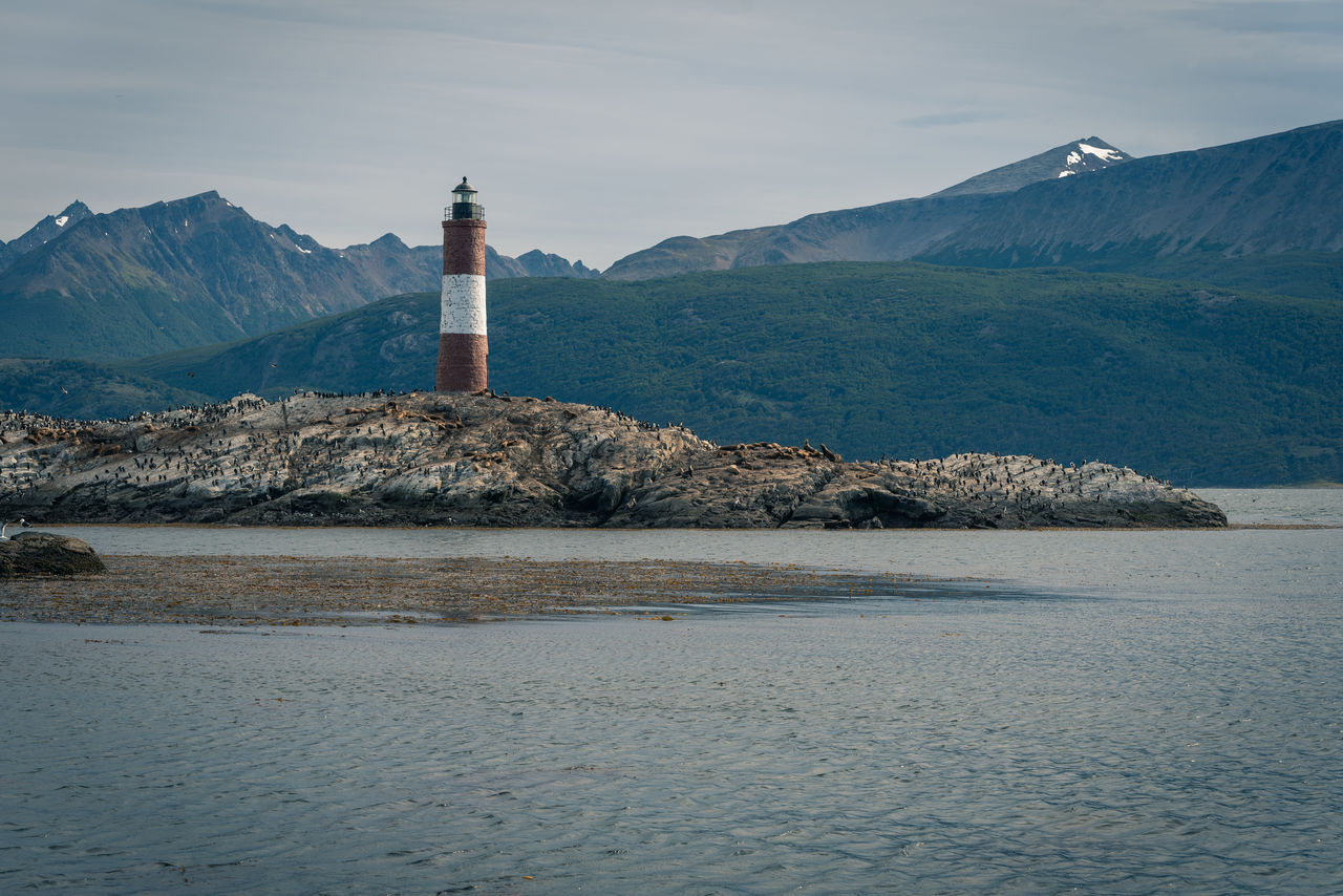 LIGHTHOUSE BY BUILDINGS AGAINST SKY