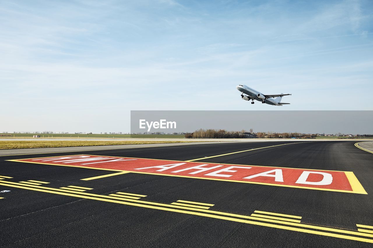 Traffic at airport. airplane taking off from runway during sunny day.