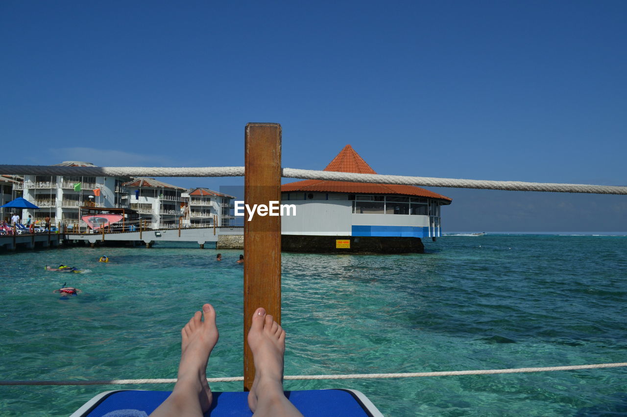 WOMAN RELAXING ON SWIMMING POOL