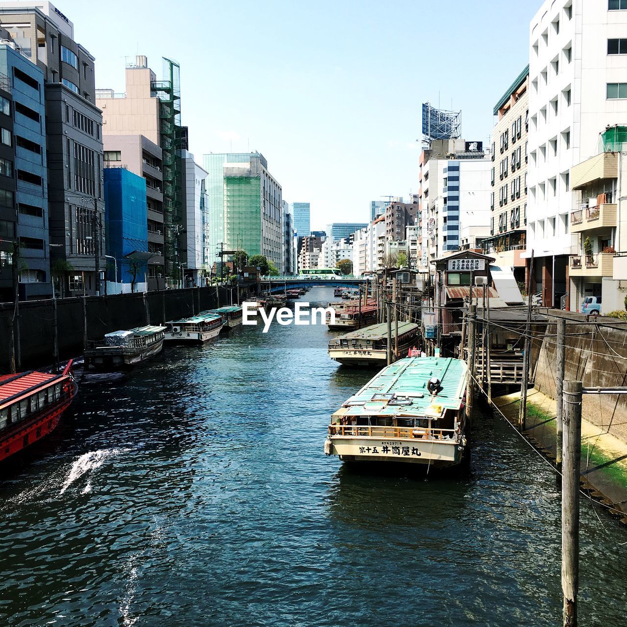 Canal amidst buildings in city against sky