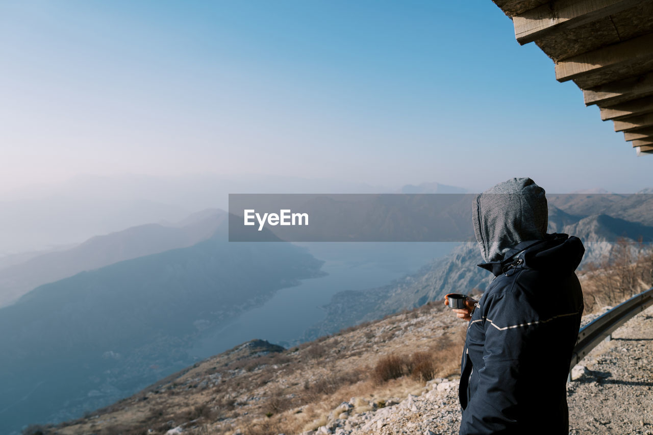 rear view of man standing against mountain