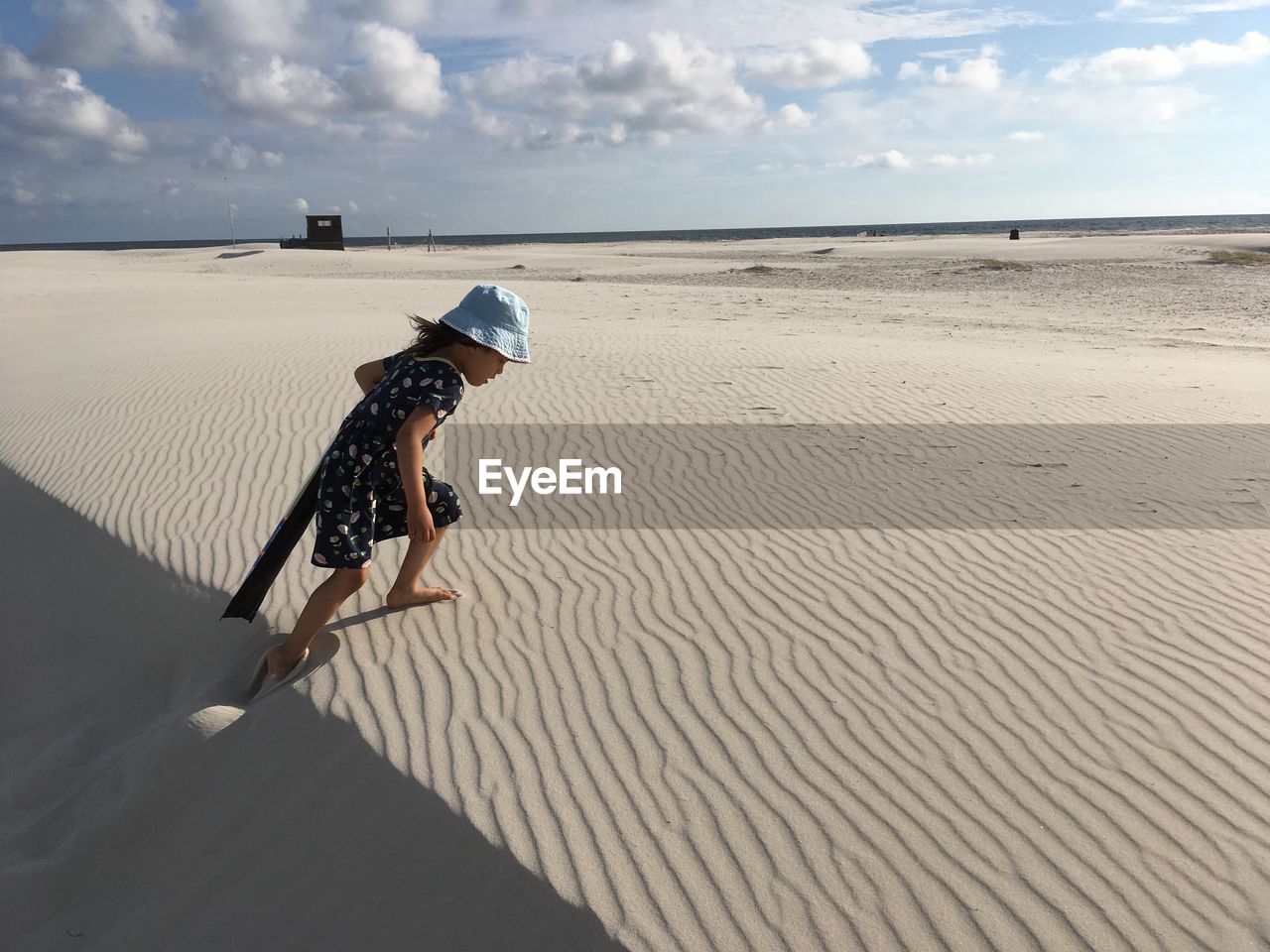 Side view of girl walking on sand at beach