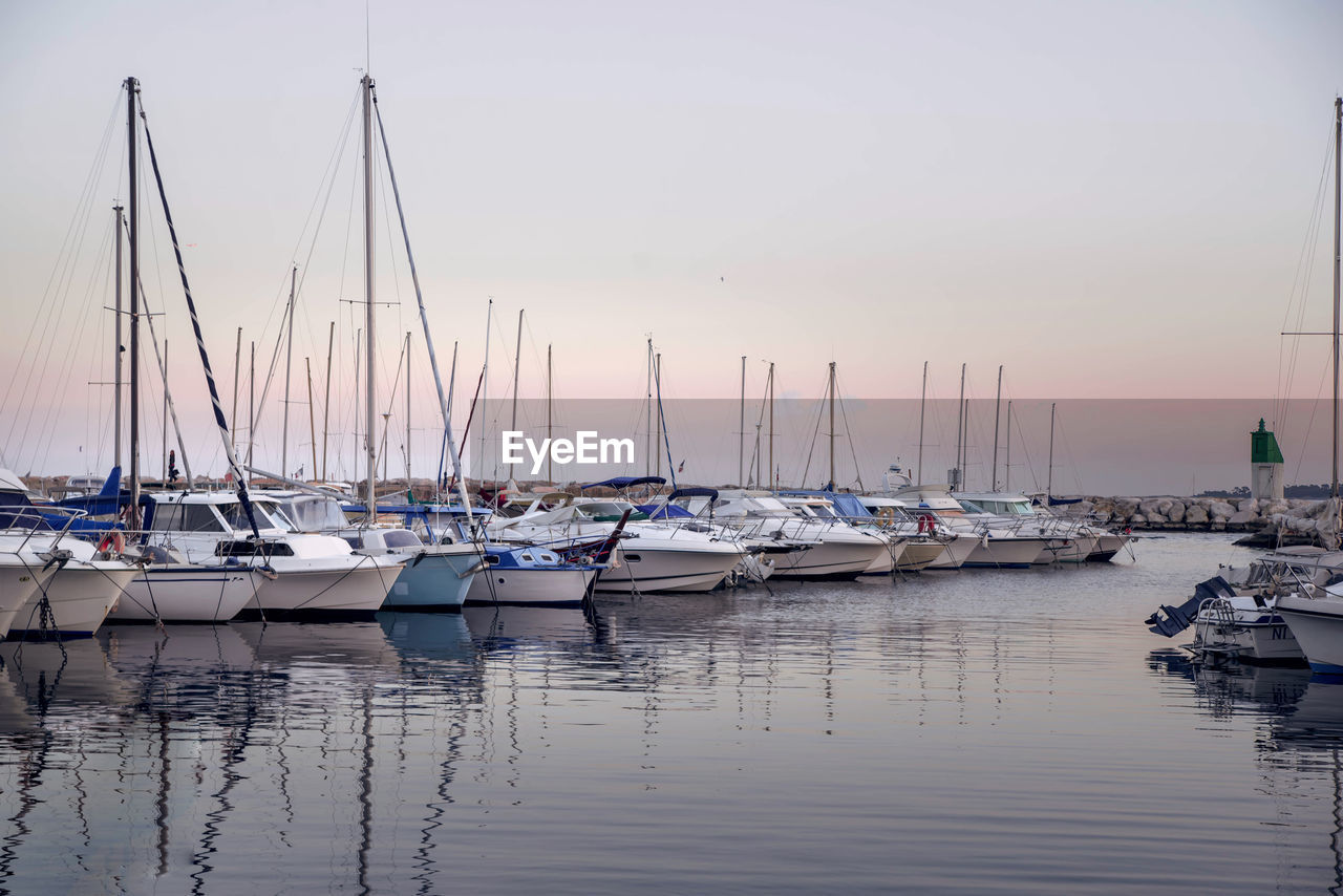 SAILBOATS MOORED IN HARBOR