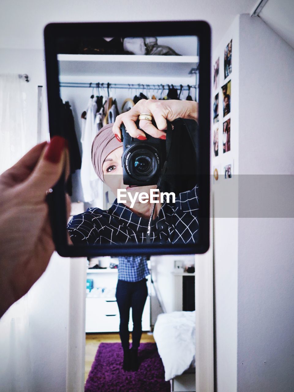 Reflection of woman in hand mirror while photographing through camera