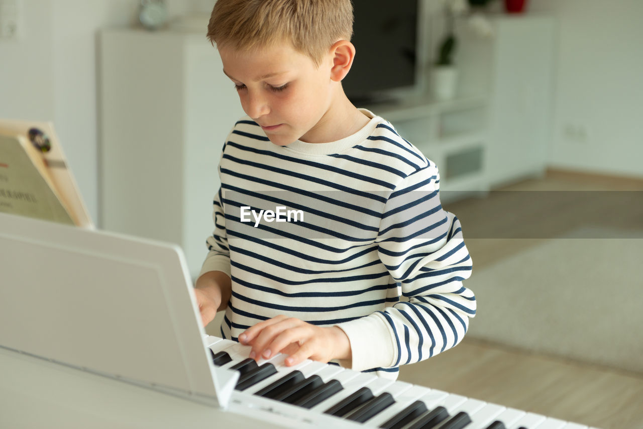 BOY PLAYING WITH PIANO AT HOME