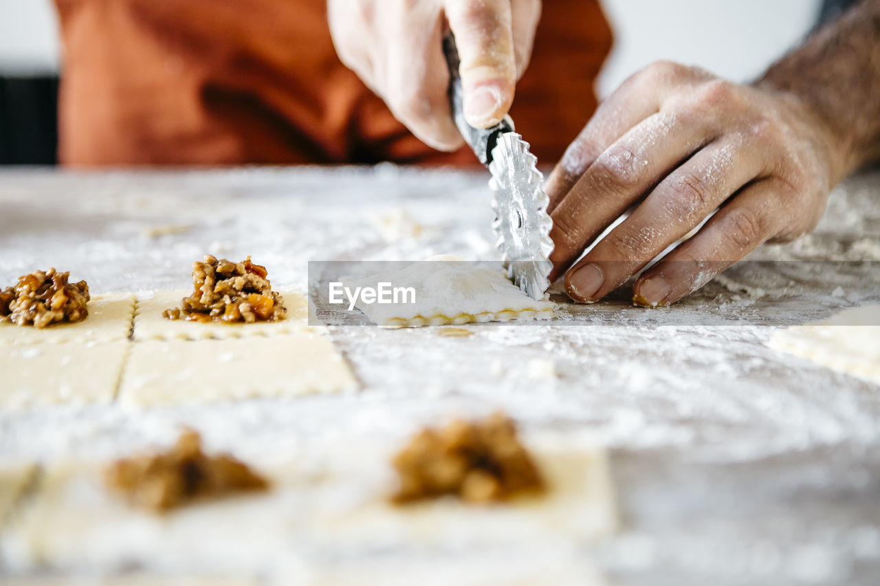 Cropped hands of male chef preparing food on table