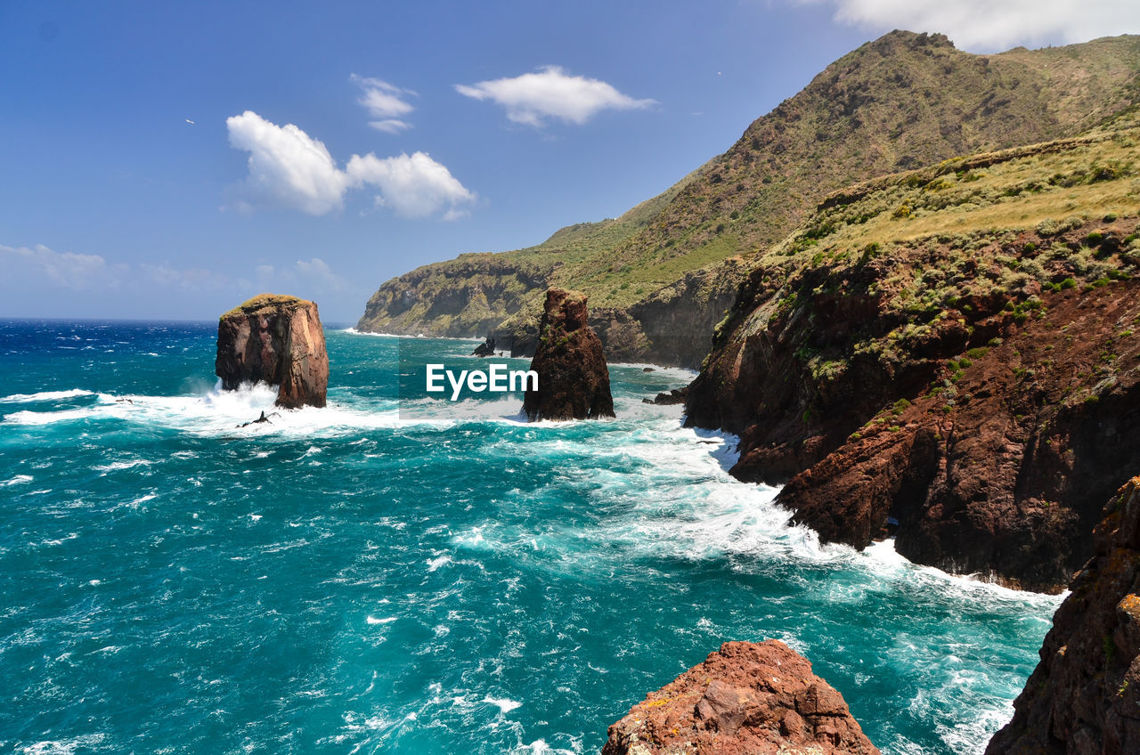 Scenic view of sea and mountains against sky