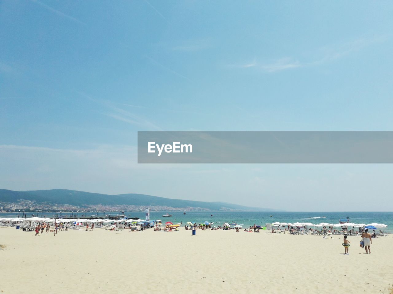 Group of people on beach against sky