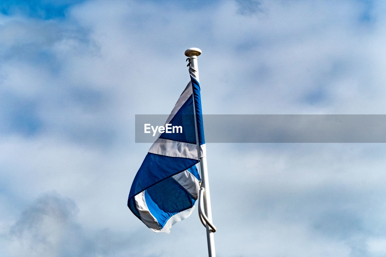 LOW ANGLE VIEW OF FLAG AGAINST CLOUDY SKY