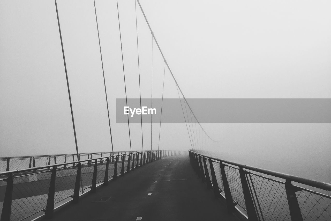 Empty road on bridge against clear sky