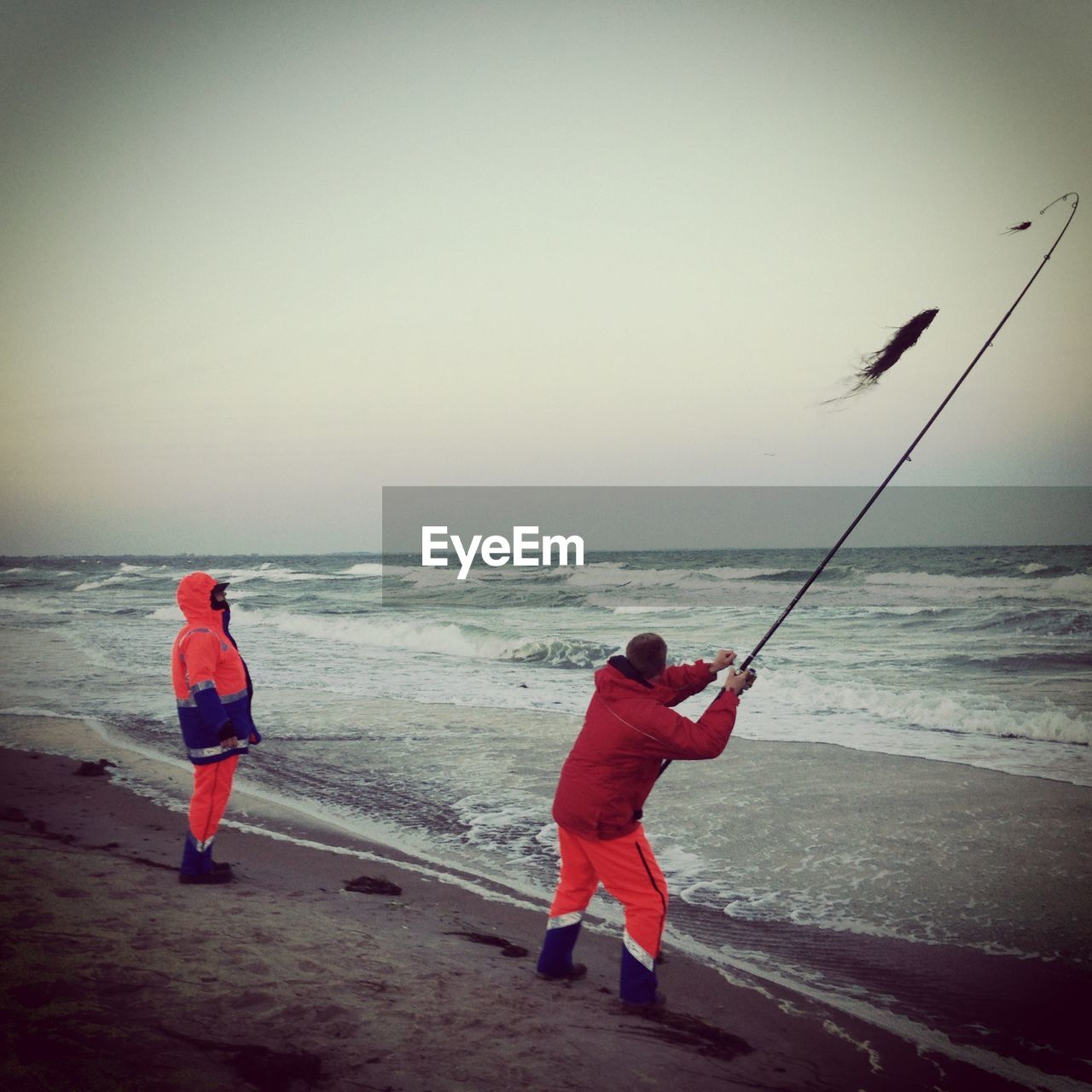 REAR VIEW OF TWO BOYS ON BEACH