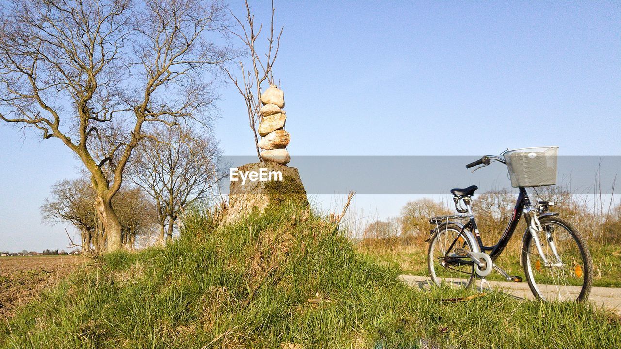 BICYCLE ON FIELD AGAINST SKY