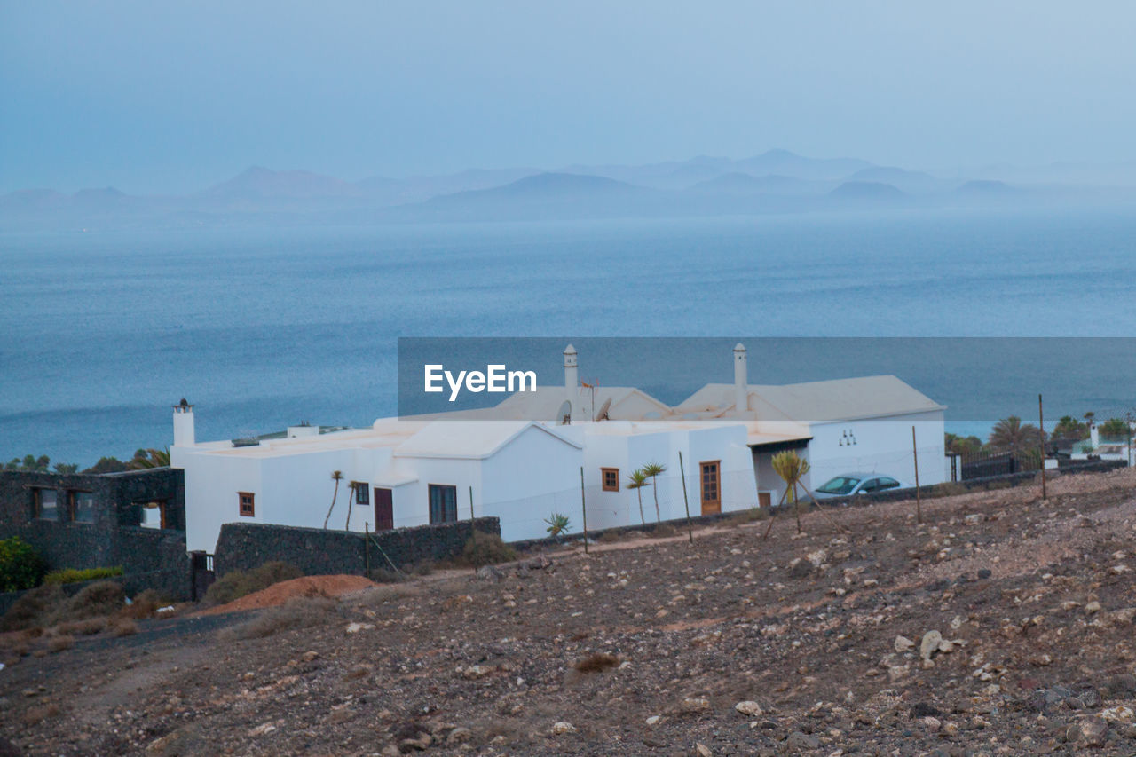 HOUSES BY SEA AGAINST SKY