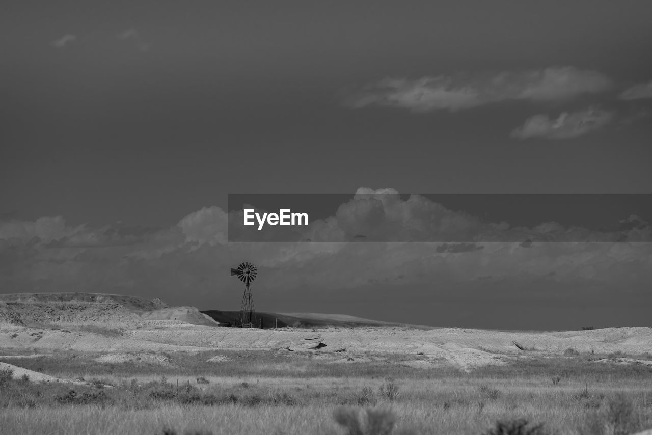 Scenic view of field against sky with windmill