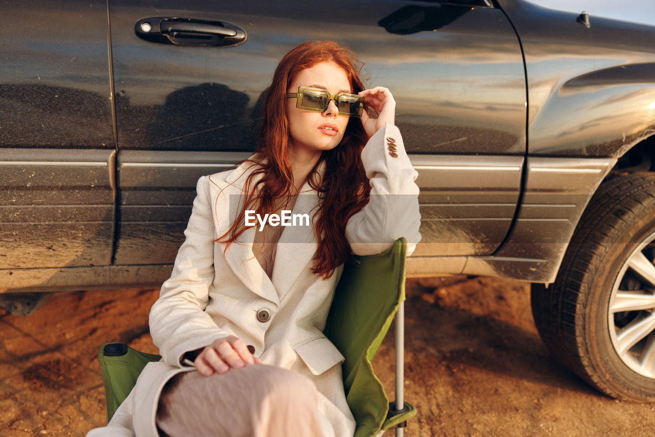 portrait of young woman wearing sunglasses while sitting in car