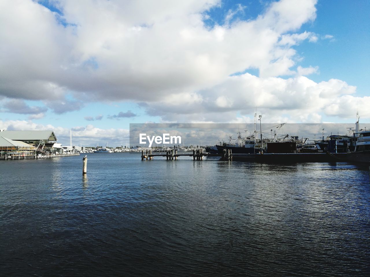 BOATS MOORED IN SEA AGAINST SKY