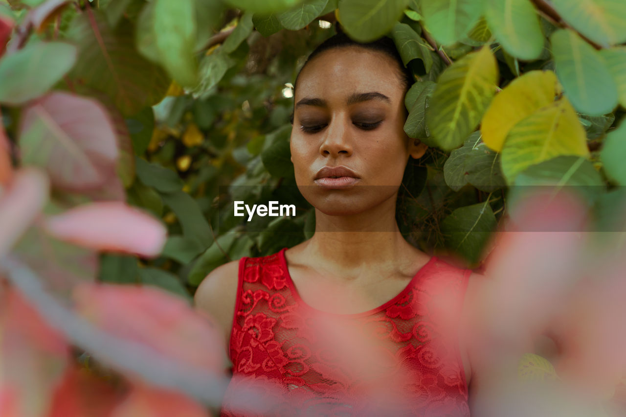 PORTRAIT OF BEAUTIFUL YOUNG WOMAN WITH LEAVES