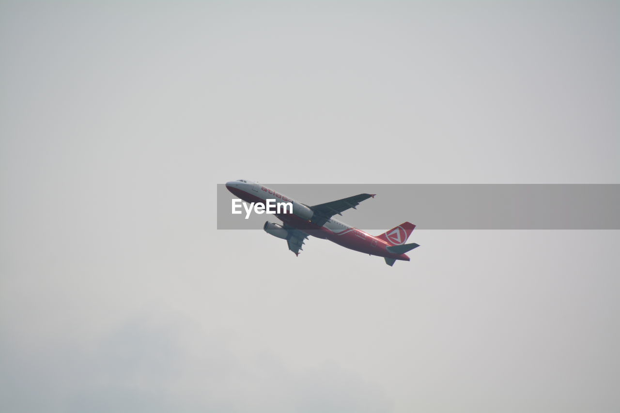 Low angle view of airplane flying against clear sky