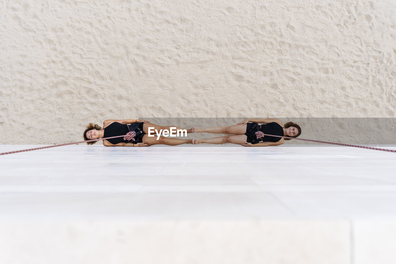 Aerial dancers hanging against wall