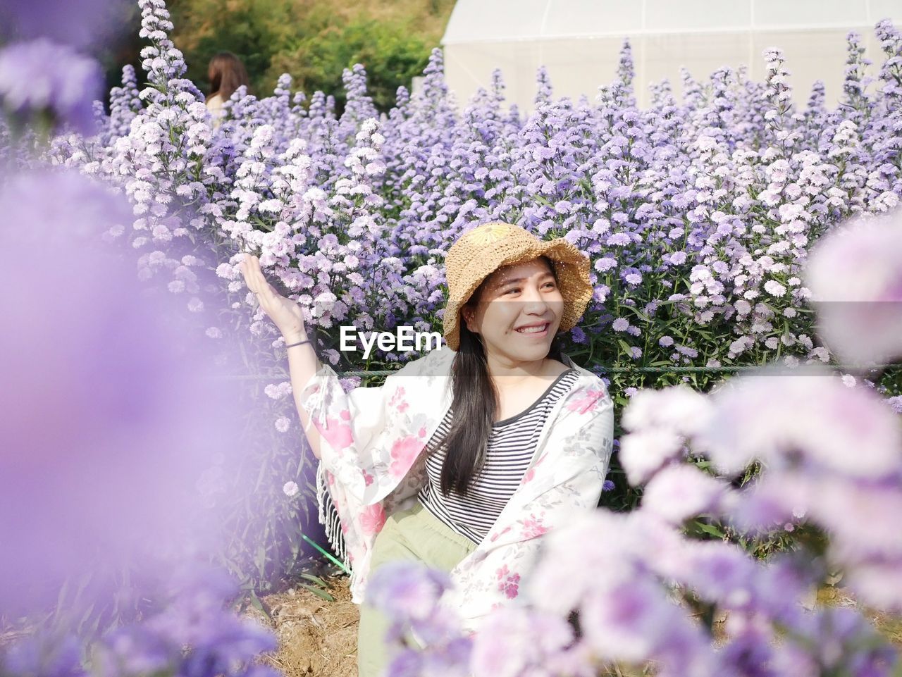 Portrait of smiling woman with purple flowers