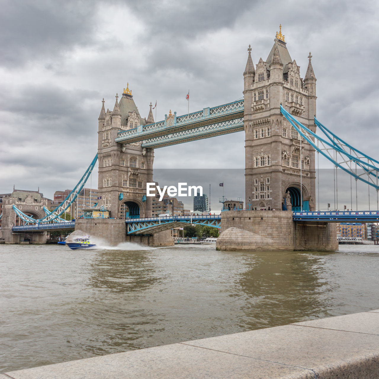 London bridge with a police boat speeding underneath