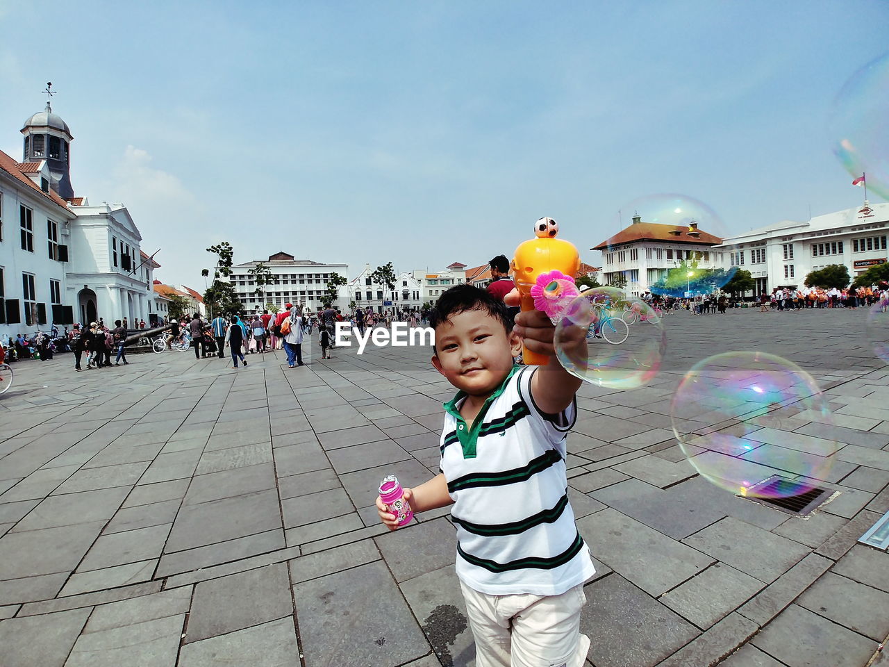 Boy playing on road against sky