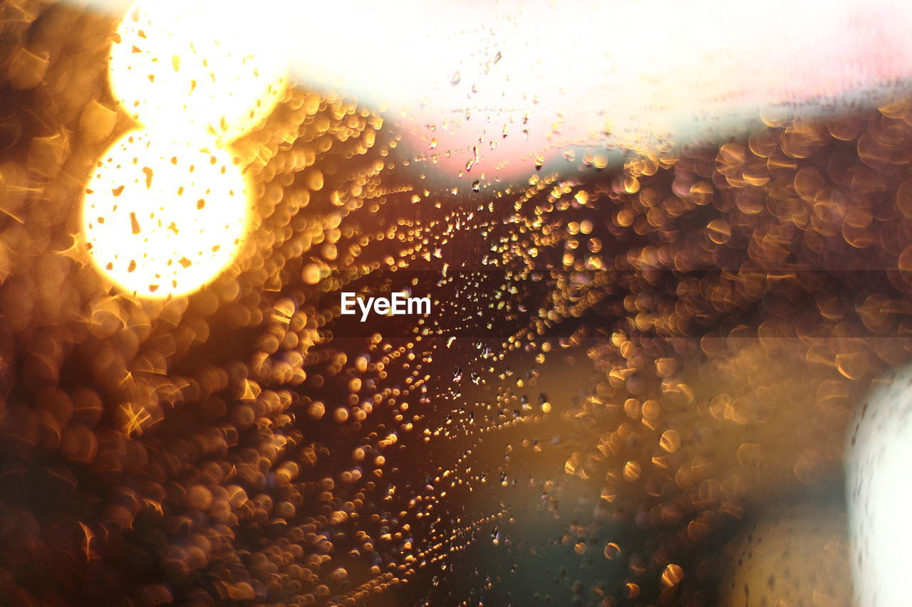 CLOSE-UP OF RAINDROPS ON GLASS WINDOW