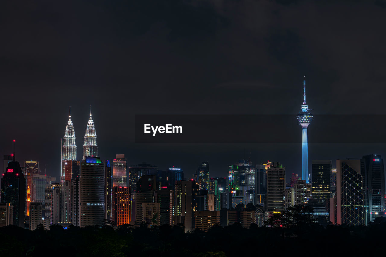 Illuminated kuala lumpur cityscape at night against clear sly with petronas twin towers and kl tower 