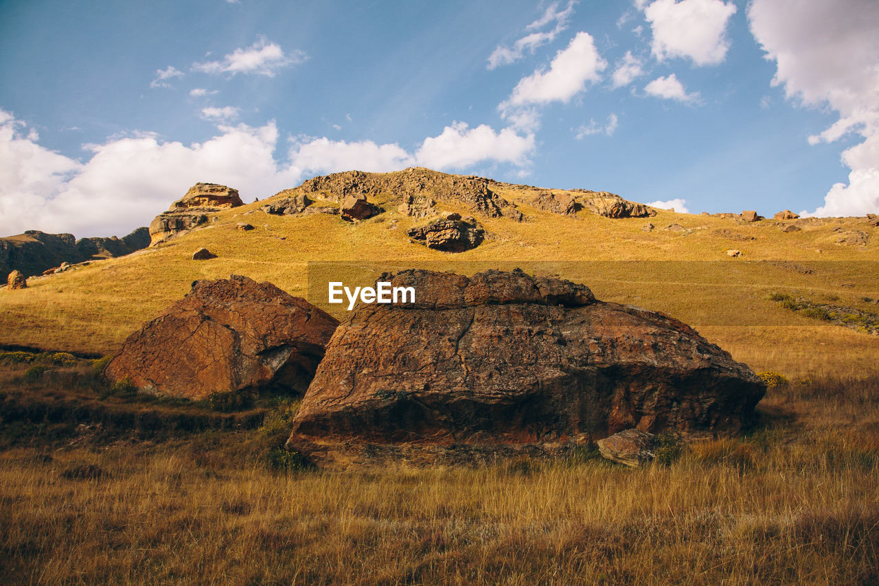 Scenic view of rocks on field against sky