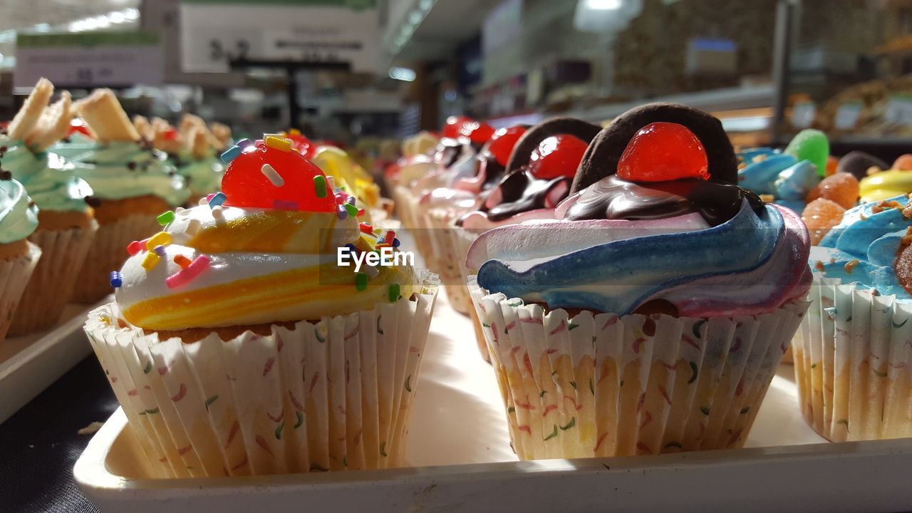 CLOSE-UP OF CUPCAKES ON TABLE AT MARKET