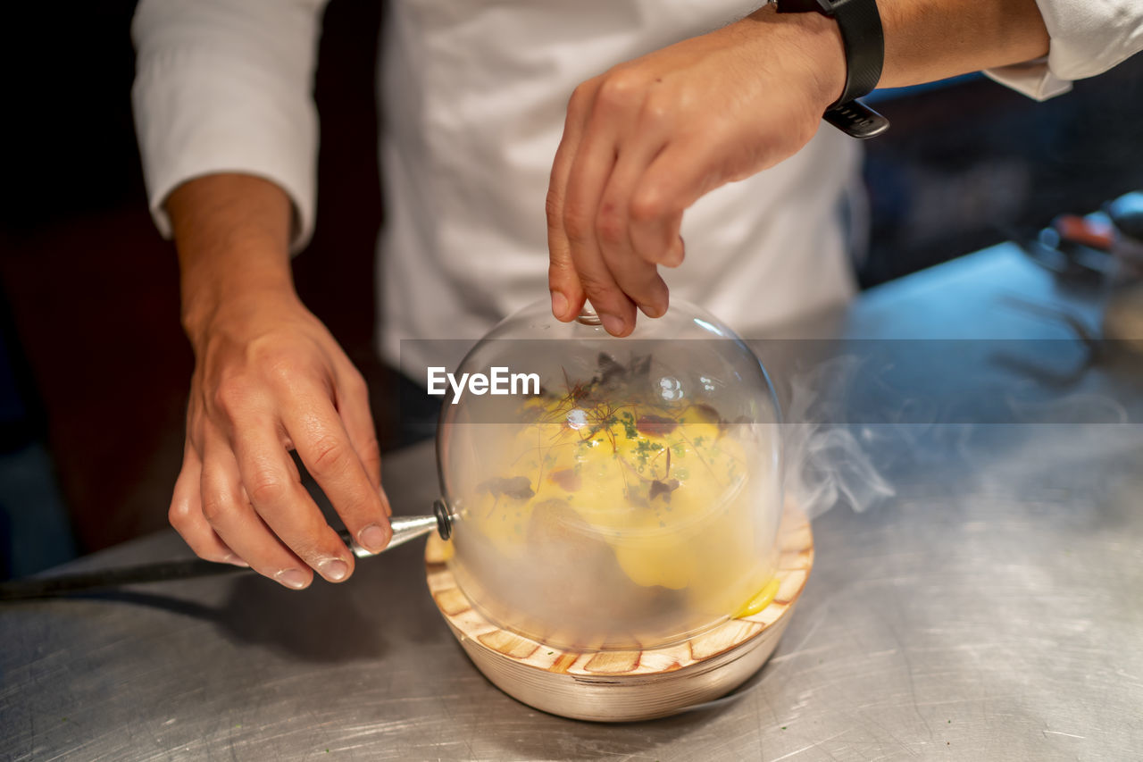 Male chef preparing food at counter in kitchen at restaurant