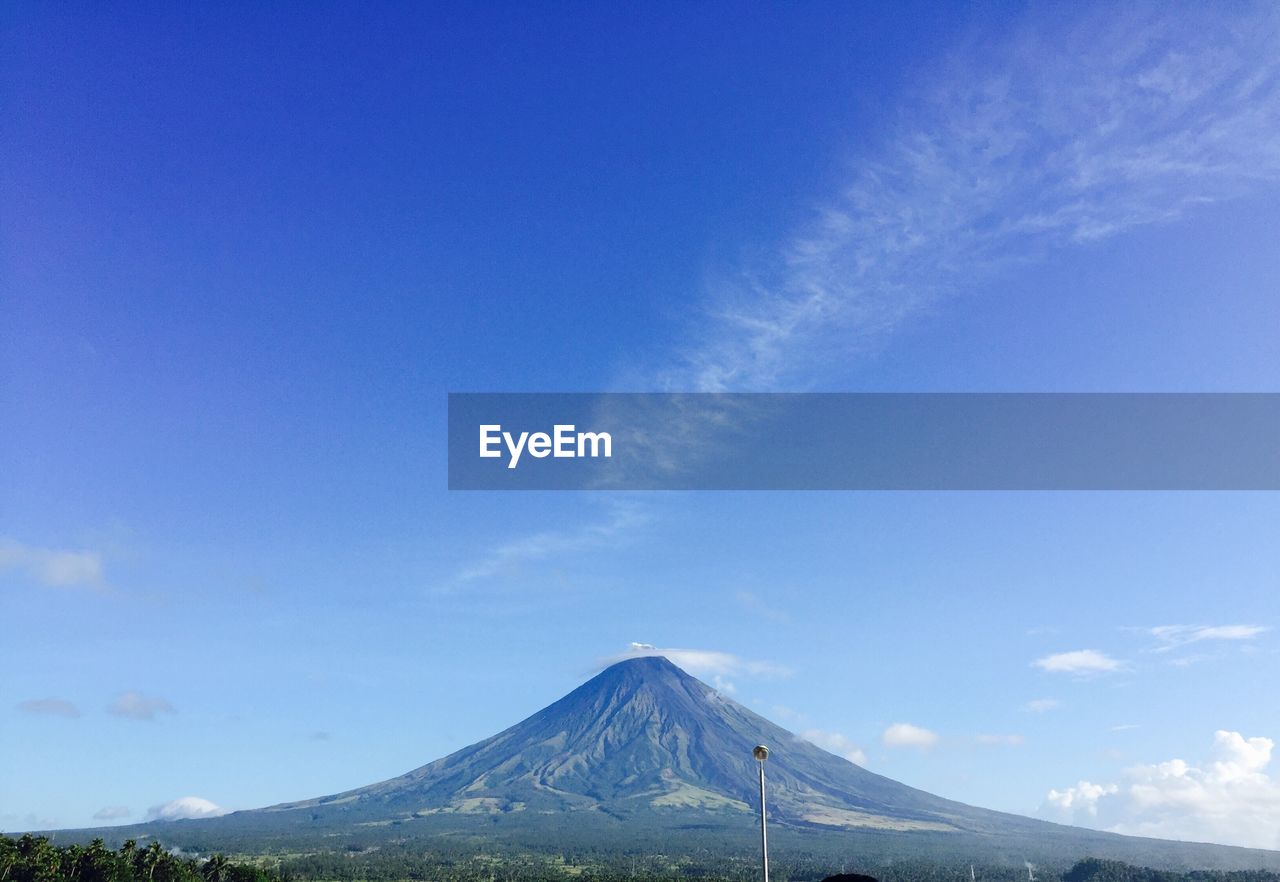 Scenic view of mountains against blue sky