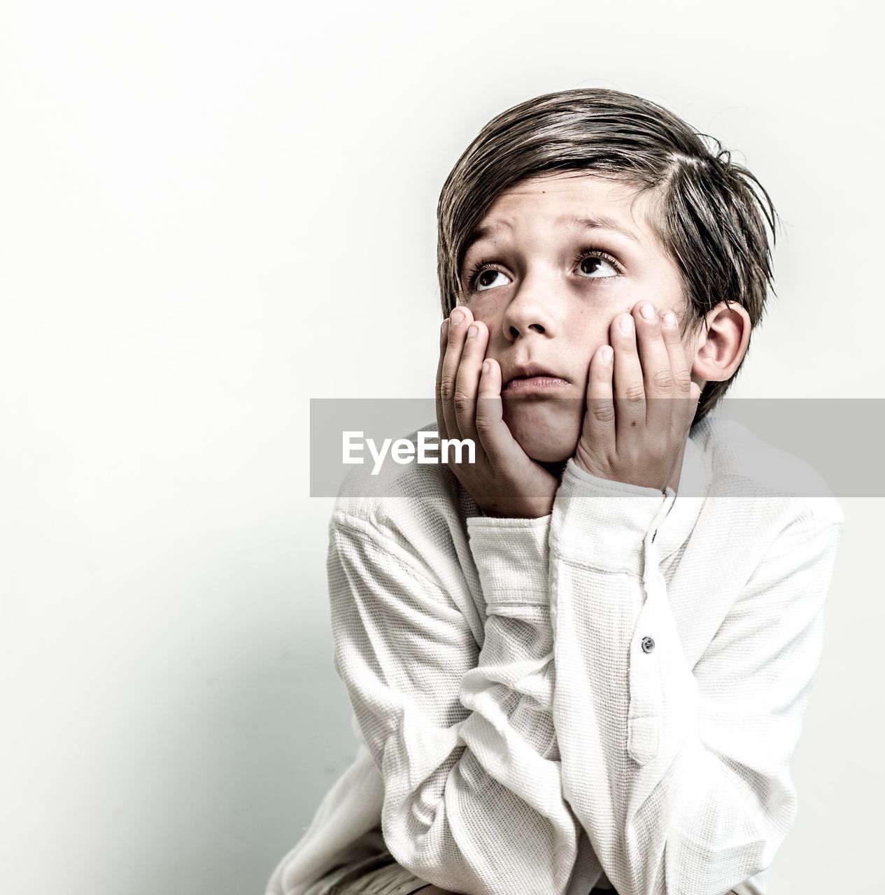 Boy looking away against white background