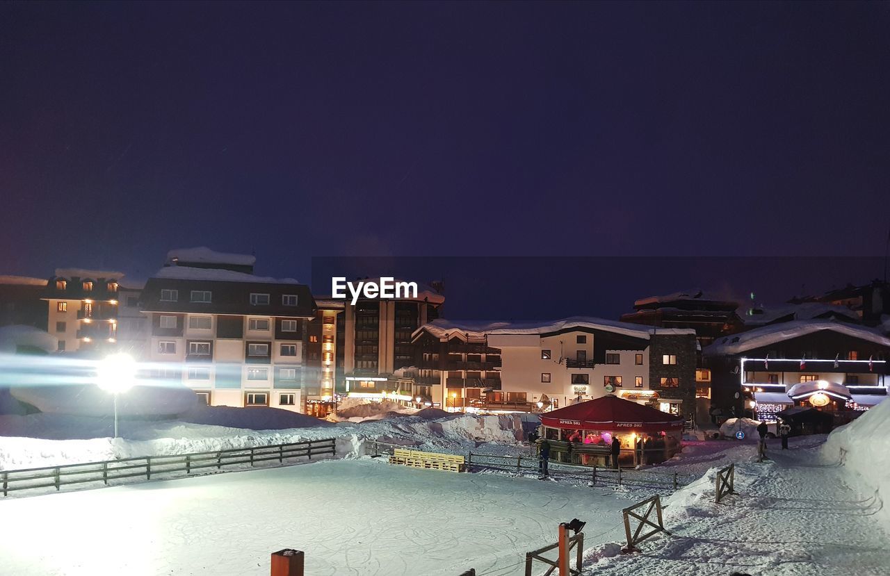 PEOPLE IN ILLUMINATED CITY AT NIGHT