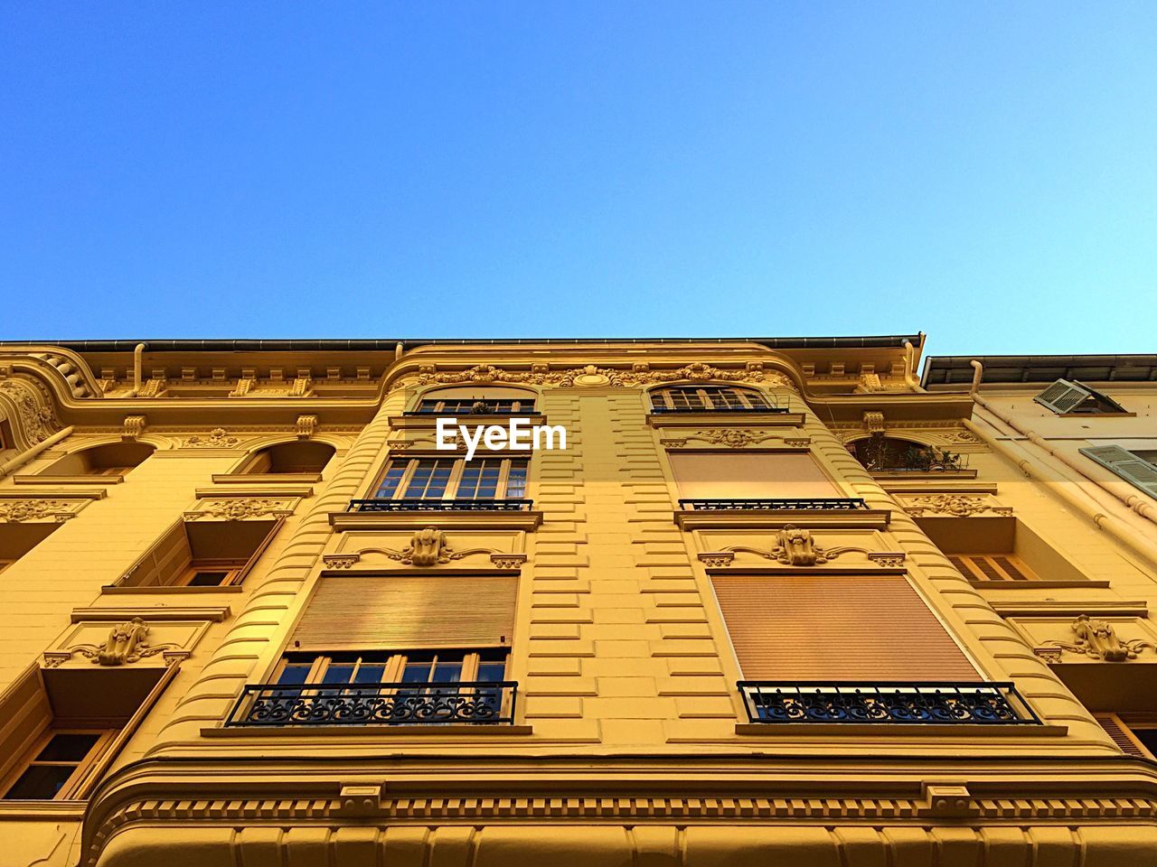 LOW ANGLE VIEW OF BUILDINGS AGAINST CLEAR BLUE SKY