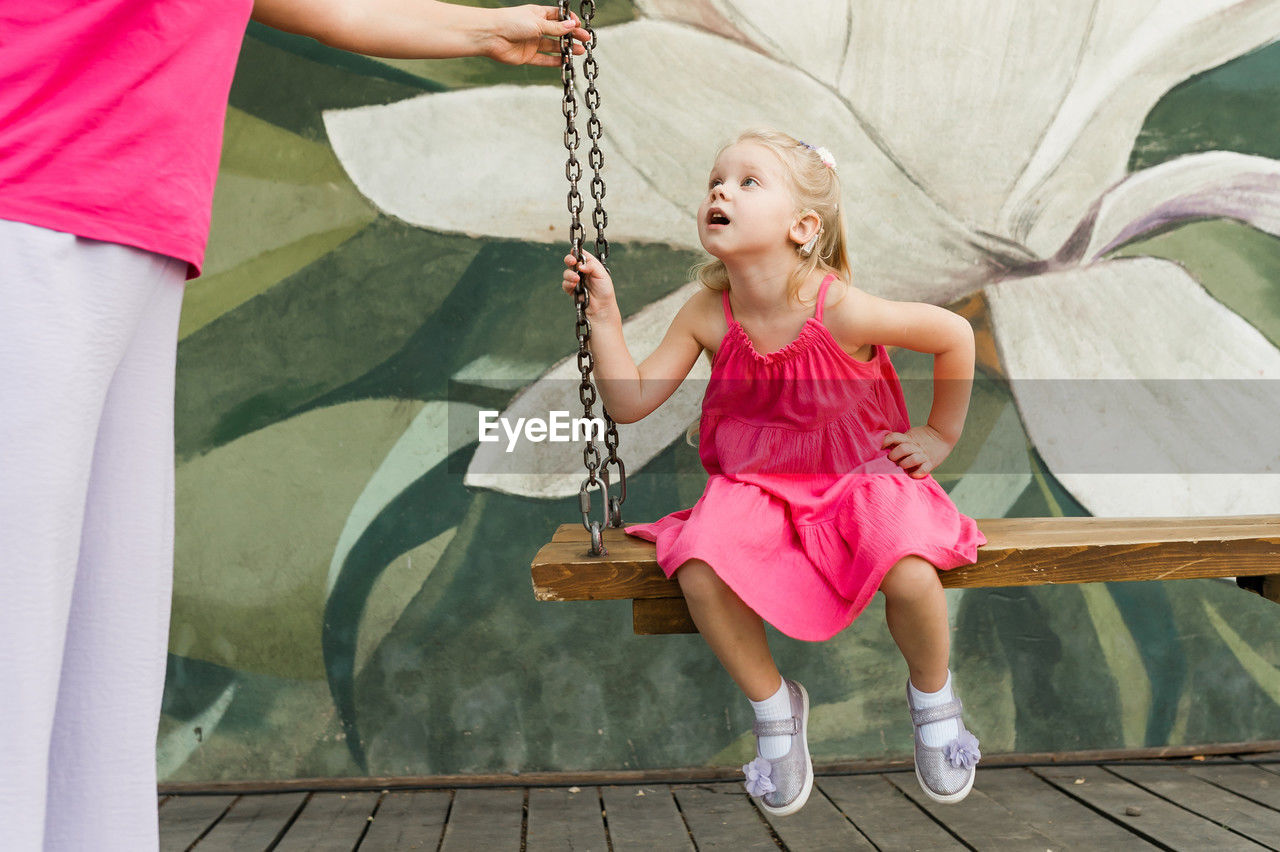 full length of boy sitting on swing at park