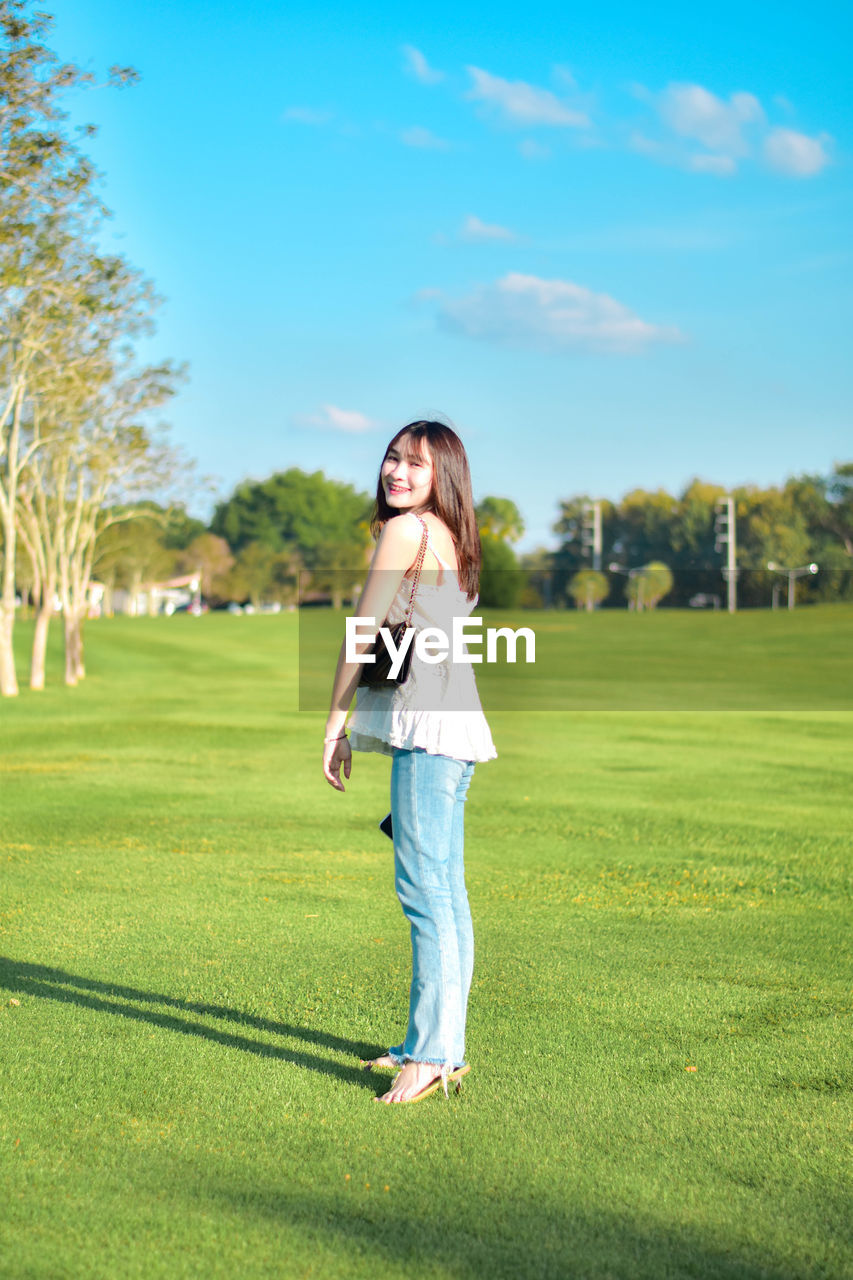 Full length of young woman standing on field