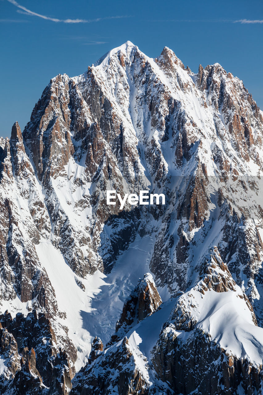 Scenic view of snowcapped mountain against blue sky