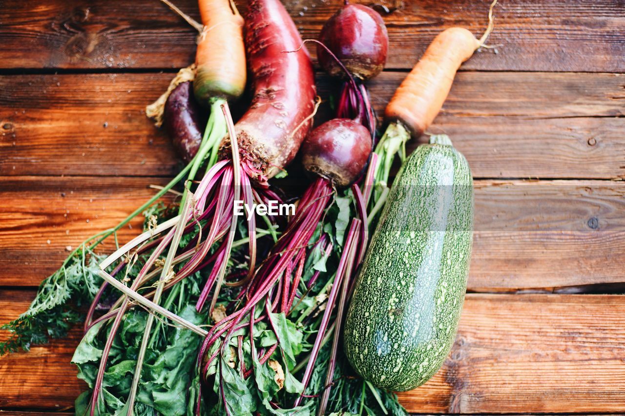 HIGH ANGLE VIEW OF VEGETABLES ON WOODEN TABLE