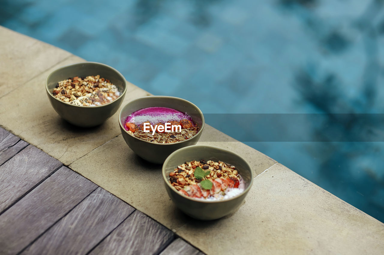 Three ready to eat bowls of strawberry, peanut butter and pitaya muesli