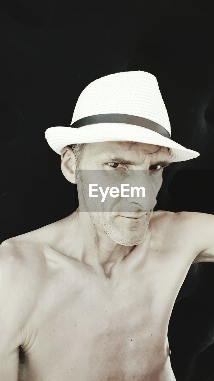 Portrait of mature man against black background