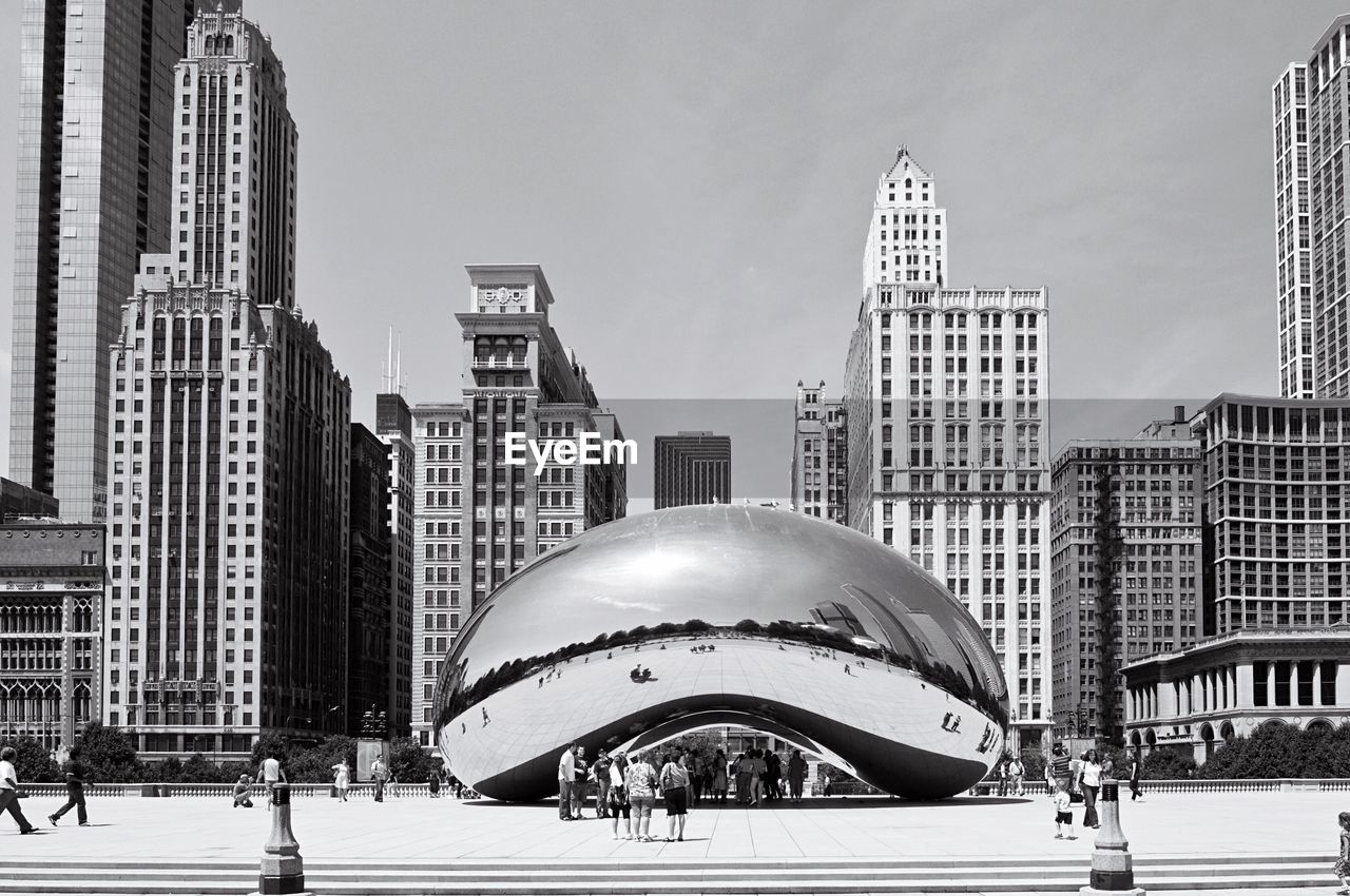 Cloud gate sculpture at millennium park against sky in city